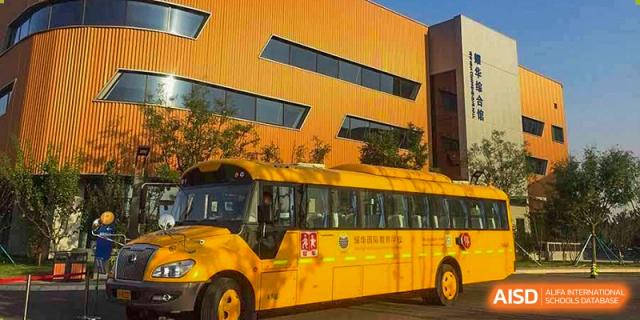 A school bus is parked outside Yew Wah International Education School Of Beijing Yizhuang Campus.