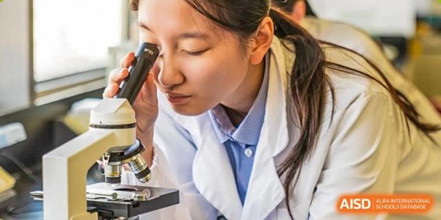 A female student at Yew Wah International Education School Of Beijing Yizhuang Campus looks into a microscope.