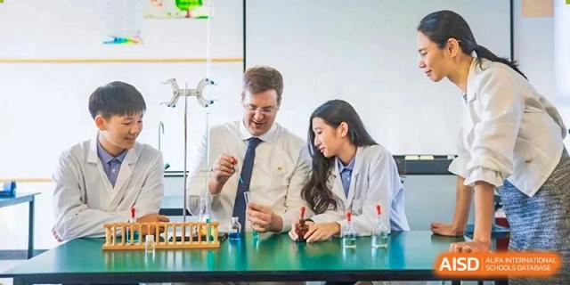 A teacher helps a male and female student with a chemistry experiment at Yew Wah International Education School Of Beijing Yizhuang Campus.