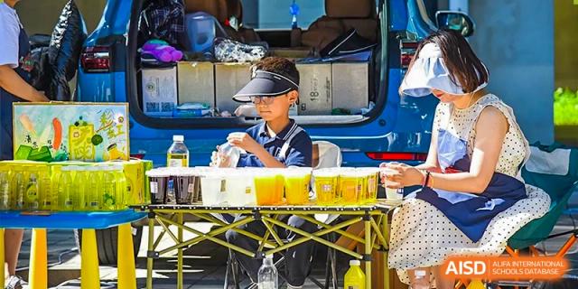 A student worker wearing a cap and serving food or drink from a canteen or service area at Yitian Hudson School.