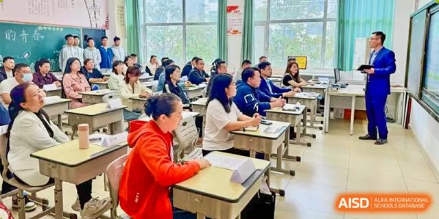 Students at ZHANGQIU BILINGUAL INTERNATIONAL SCHOOL sit at individual desks and take a test or work on an assignment in a busy classroom.
