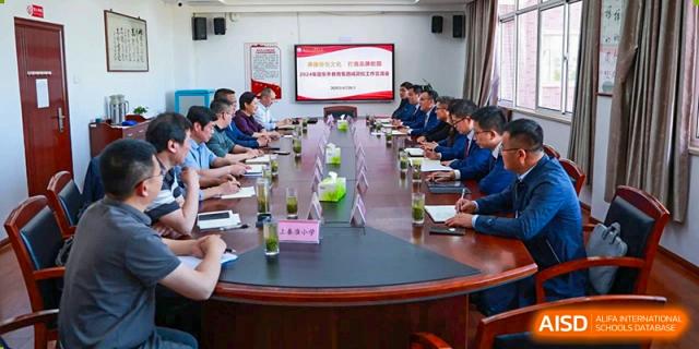 A group of teachers from Nanjing Dongshan Foreign Language School International Department are attending a meeting around a large table.