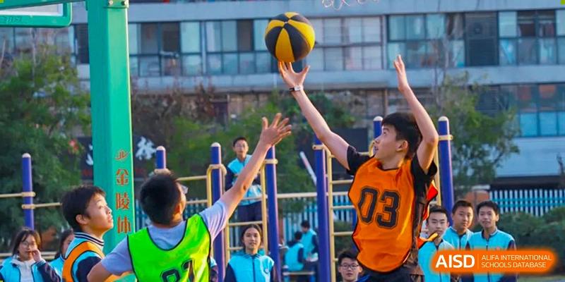 Students playing a basketball game at an outdoor court at Nanjing Dongshan Foreign Language School International Department