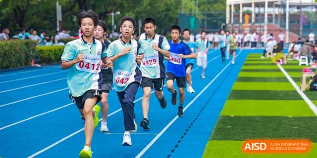 Students from Nanjing Dongshan Foreign Language School International Department are running in a race on a blue track.