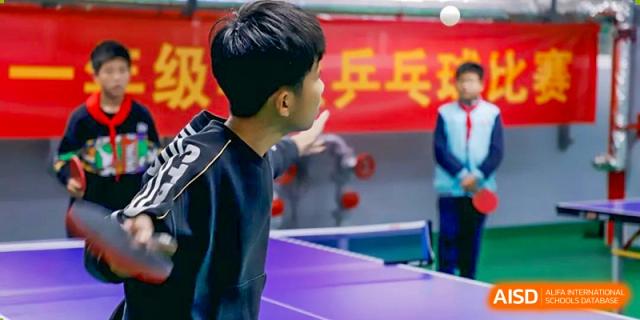 A student from Nanjing Dongshan Foreign Language School International Department is playing table tennis indoors.