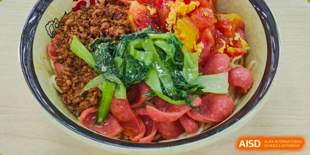A close-up of a dish with green vegetables and sliced meat served in the cafeteria at Nanjing Dongshan Foreign Language School International Department.