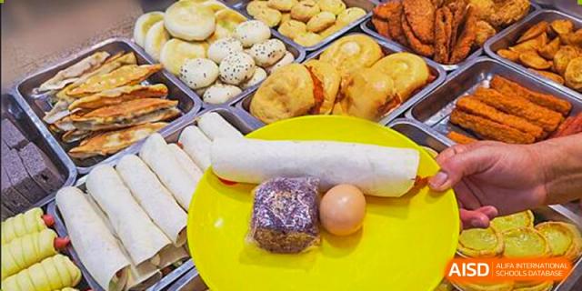 A plate with a large steamed bun, a purple food item, and an egg is shown at Nanjing Dongshan Foreign Language School International Department.