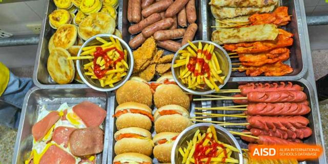 A tray filled with hamburgers, hot dogs, and french fries is ready to be served at Nanjing Dongshan Foreign Language School International Department.