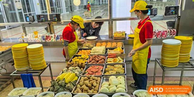 Cafeteria staff from Nanjing Dongshan Foreign Language School International Department serving a variety of dishes to students.