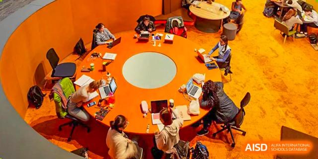 A group of students from Nanning No.2 High School International Division is collaborating around a circular table in a creative learning space.