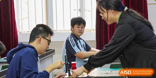A student from Nanning No.2 High School International Division is conducting a science experiment in a lab.