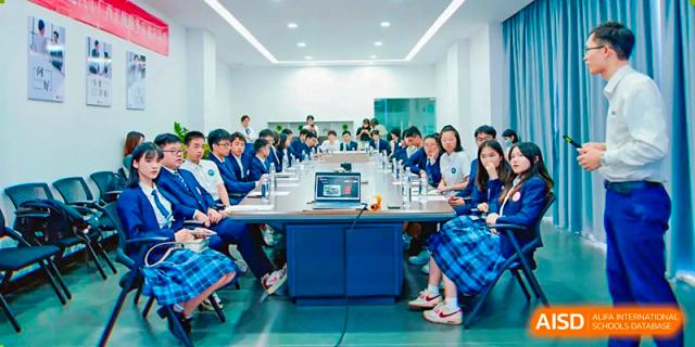 Students from Nanning No.2 High School International Division are seated at a long table during a class or meeting.