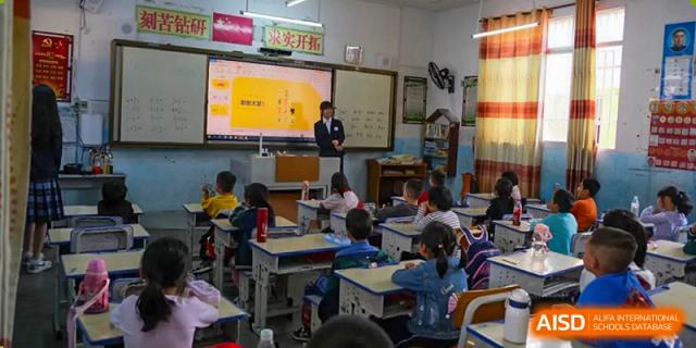 A teacher is standing at the front of a classroom, instructing students from Nanning No.2 High School International Division.