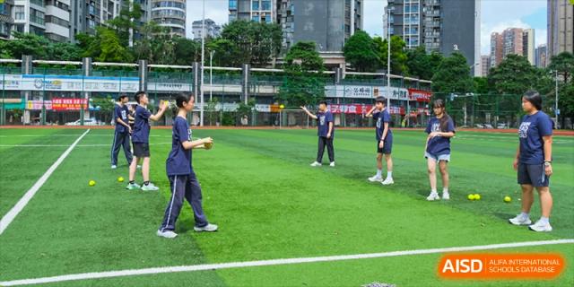 Students from Nanning No.2 High School International Division are playing soccer on a grassy field.