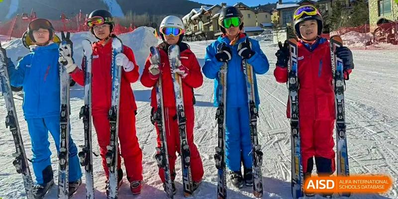 Students from Nanning No.2 High School International Division are posing in red and blue ski gear with skis.