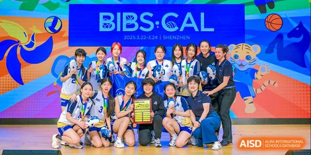A group of students from BASIS International & Bilingual Schools Chengdu posing together with a banner, celebrating a victory.
