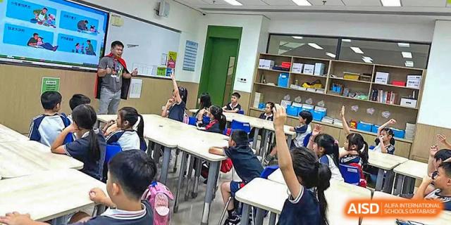 Students at BASIS International & Bilingual Schools Chengdu in a classroom, with one student raising their hand to ask a question.