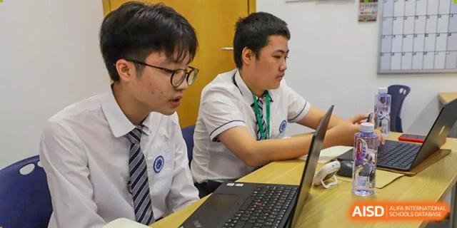 Students from BASIS International & Bilingual Schools Chengdu working together on a project with a laptop.