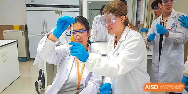 A science teacher at BASIS International & Bilingual Schools Chengdu demonstrating an experiment to a student.