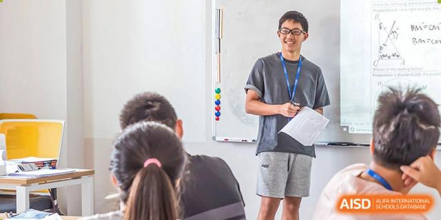 A teacher at BASIS International & Bilingual Schools Chengdu standing at a whiteboard with students watching from their desks.