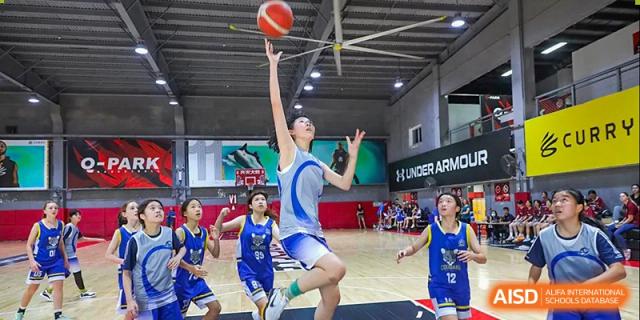 Students from BASIS International & Bilingual Schools Chengdu playing basketball in an indoor court.