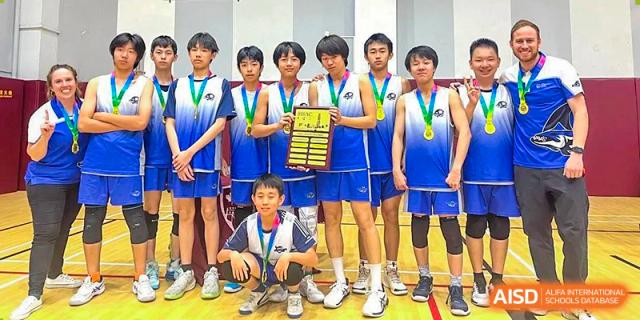 A group of students from BASIS International & Bilingual Schools Chengdu posing with medals and a trophy after a basketball tournament.