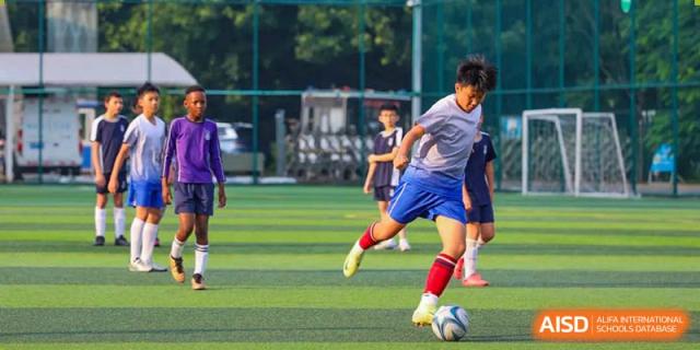 Students from BASIS International & Bilingual Schools Chengdu playing soccer on a green field.