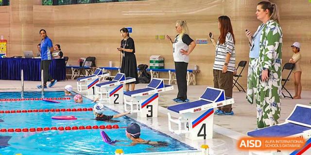 A swimming instructor coaching students at the indoor pool of BASIS International & Bilingual Schools Chengdu.