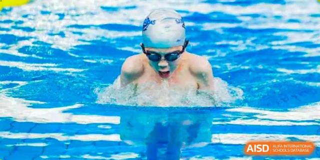 A swimmer from BASIS International & Bilingual Schools Chengdu emerging from the water in a swimming pool.