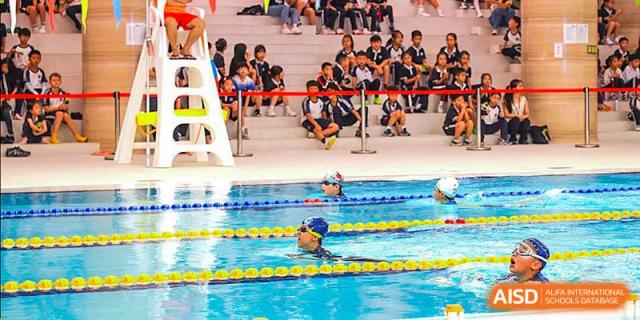 A student from BASIS International & Bilingual Schools Chengdu swimming laps in an outdoor pool during a competition.