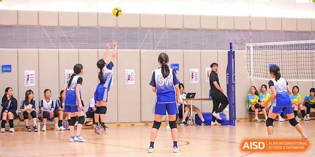 A student from BASIS International & Bilingual Schools Chengdu playing volleyball in an indoor court.