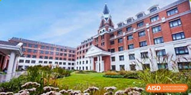 The main building of BASIS International & Bilingual Schools Chengdu with a large green lawn in front.
