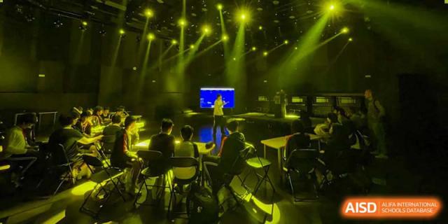 Students from BASIS International & Bilingual Schools Chengdu on a stage with bright, dramatic lighting.