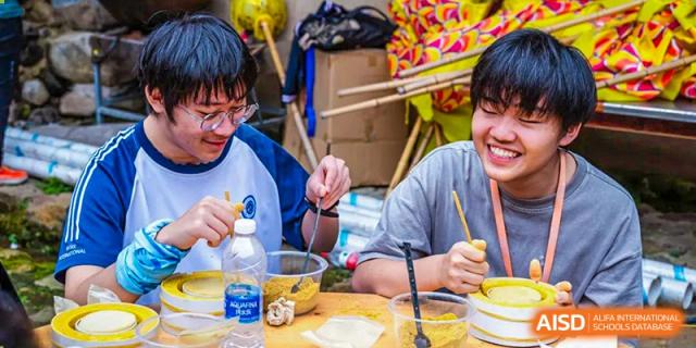 Students from BASIS International & Bilingual Schools Chengdu eating noodles from plastic containers.