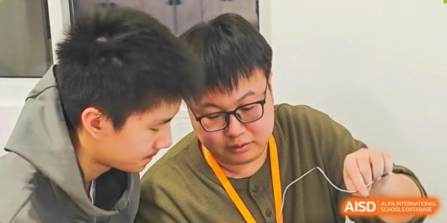 A close-up of two AcaBridge Academy students looking down intently, reviewing material or working together on a project.