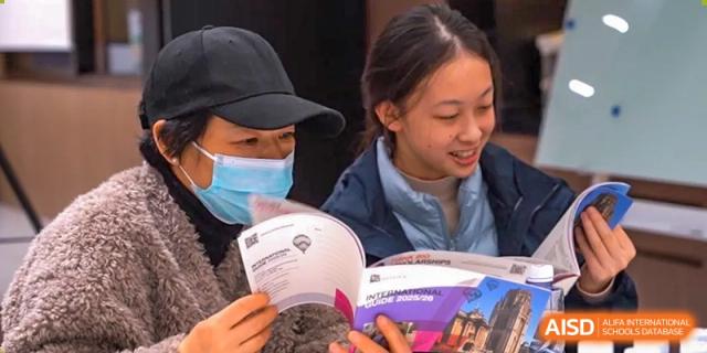 AcaBridge Academy students happily looking down and reading promotional materials or a program booklet during an event.