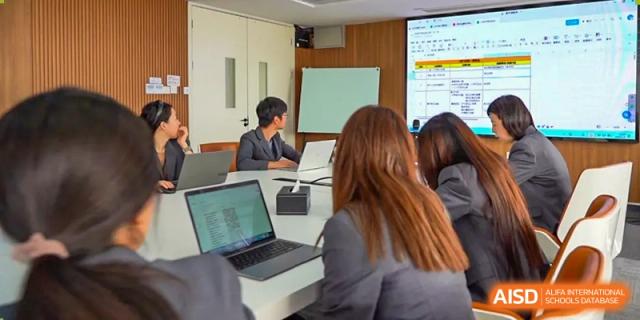 A professional meeting at AcaBridge Academy with two people discussing information shown on a laptop screen.