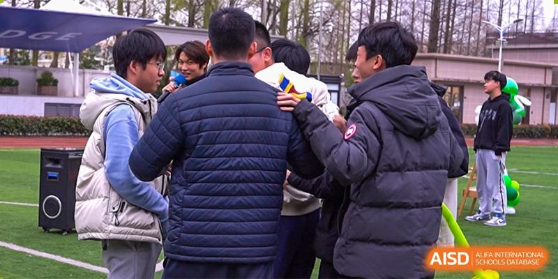 A close-up of several AcaBridge Academy students from the back, wearing winter jackets, standing in a group outdoors.