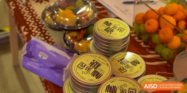 A stack of round, branded containers or tins with Chinese characters, potentially AcaBridge Academy merchandise or gifts.