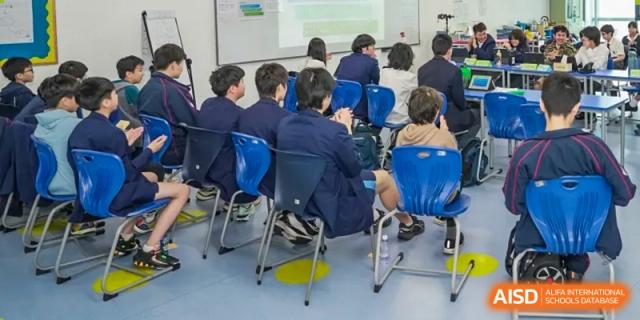 A group of Merchiston International School Shenzhen students seated in a classroom facing the front during a lesson or presentation.