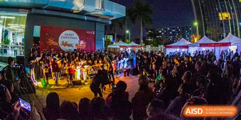 A large crowd of students and families attending a vibrant Merchiston International School Shenzhen community event or performance held outdoors at night.