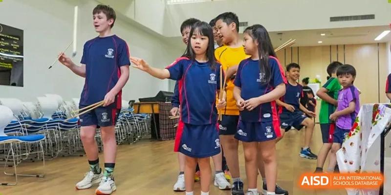 Merchiston International School Shenzhen students in their school uniform discussing an activity or instruction indoors.