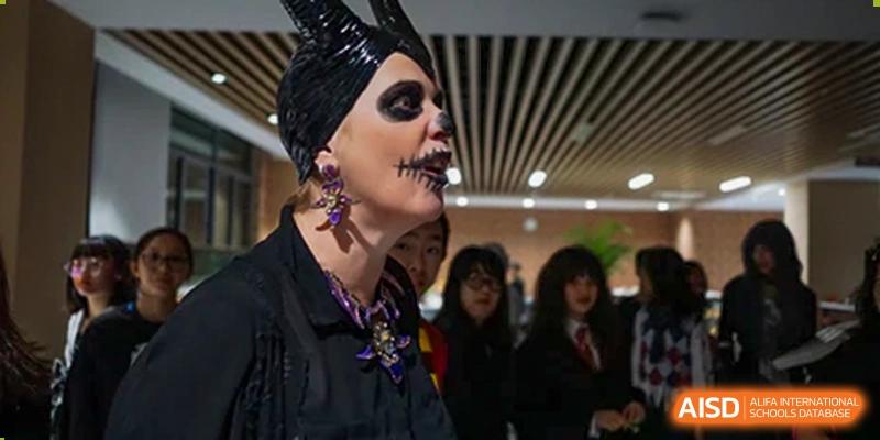 A teacher in elaborate Halloween or theatrical makeup and costume interacting with students at Merchiston International School Shenzhen.