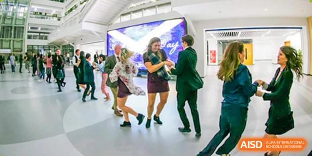A group of Merchiston International School Shenzhen students and staff dancing socially at a formal school gathering or event.
