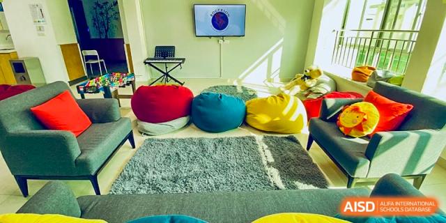 A bright, comfortable flexible learning or relaxation space at Merchiston International School Shenzhen, featuring colorful bean bags and a screen.