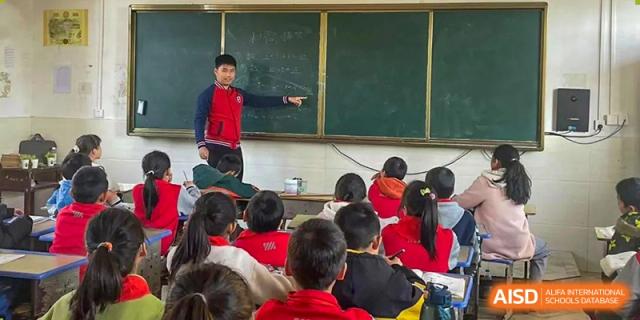 A teacher from Guangdong Country Garden School points to a blackboard while giving a lesson to students in a classroom.
