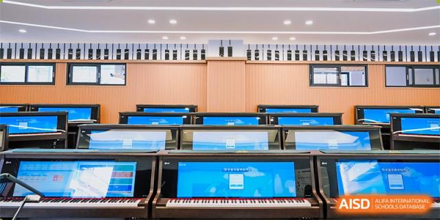 A music room at Guangdong Country Garden School with rows of digital pianos and headphones.