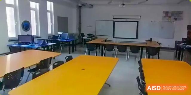 An empty classroom with desks and chairs at Shenyang International School.