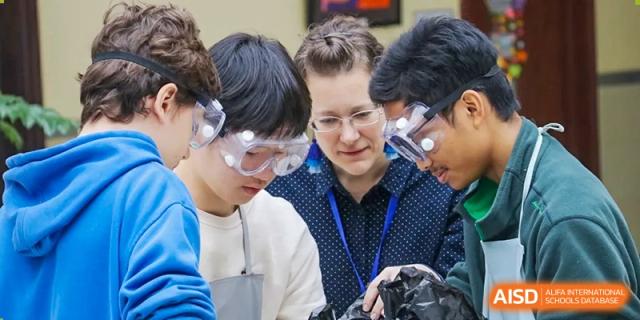 Two male students and a teacher are working on a science project in a lab at Shenyang International School.