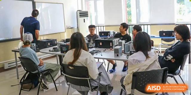 Students are using computers for a project at Shenyang International School.
